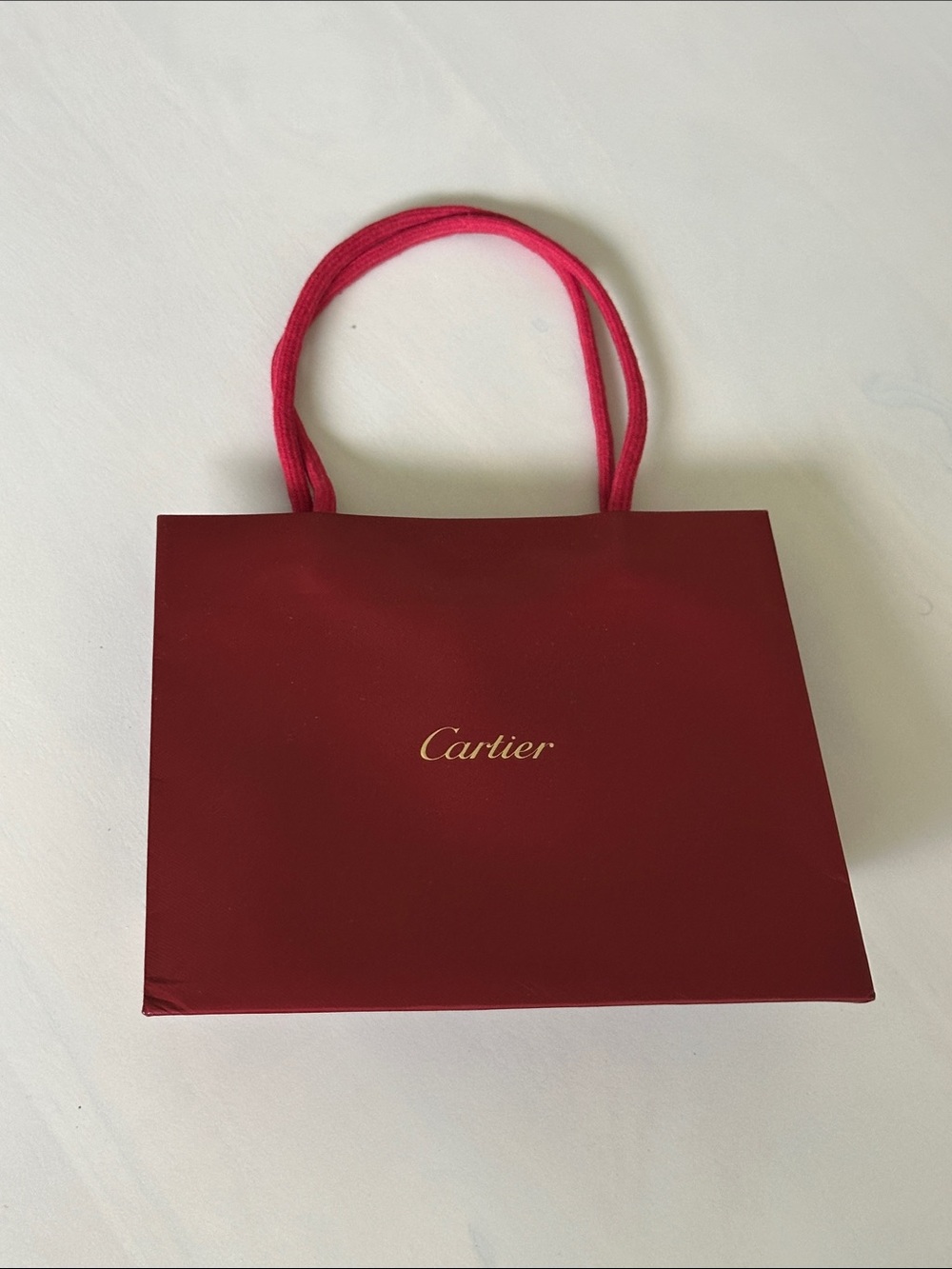 Cartier burgundy tote with gold logo and rope handles